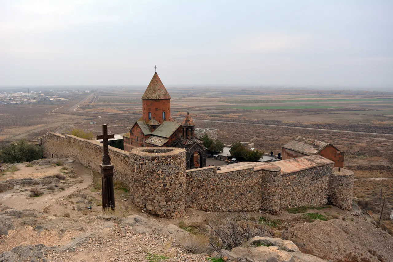 Khor Virap monastery on its low hill with the snow-capped cone of Mount Ararat behind