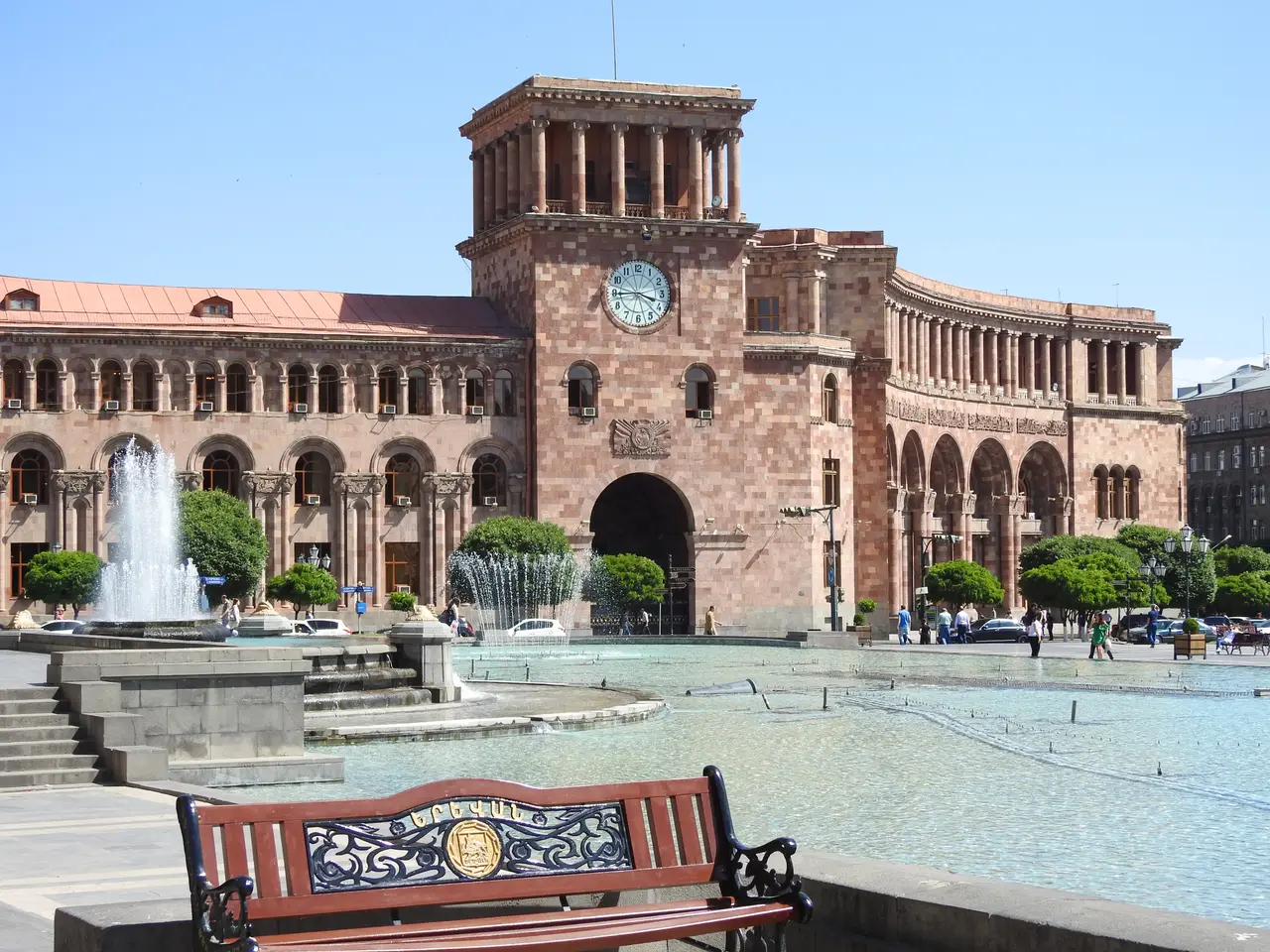 People crossing the wide pink-stone expanse of Republic Square in central Yerevan