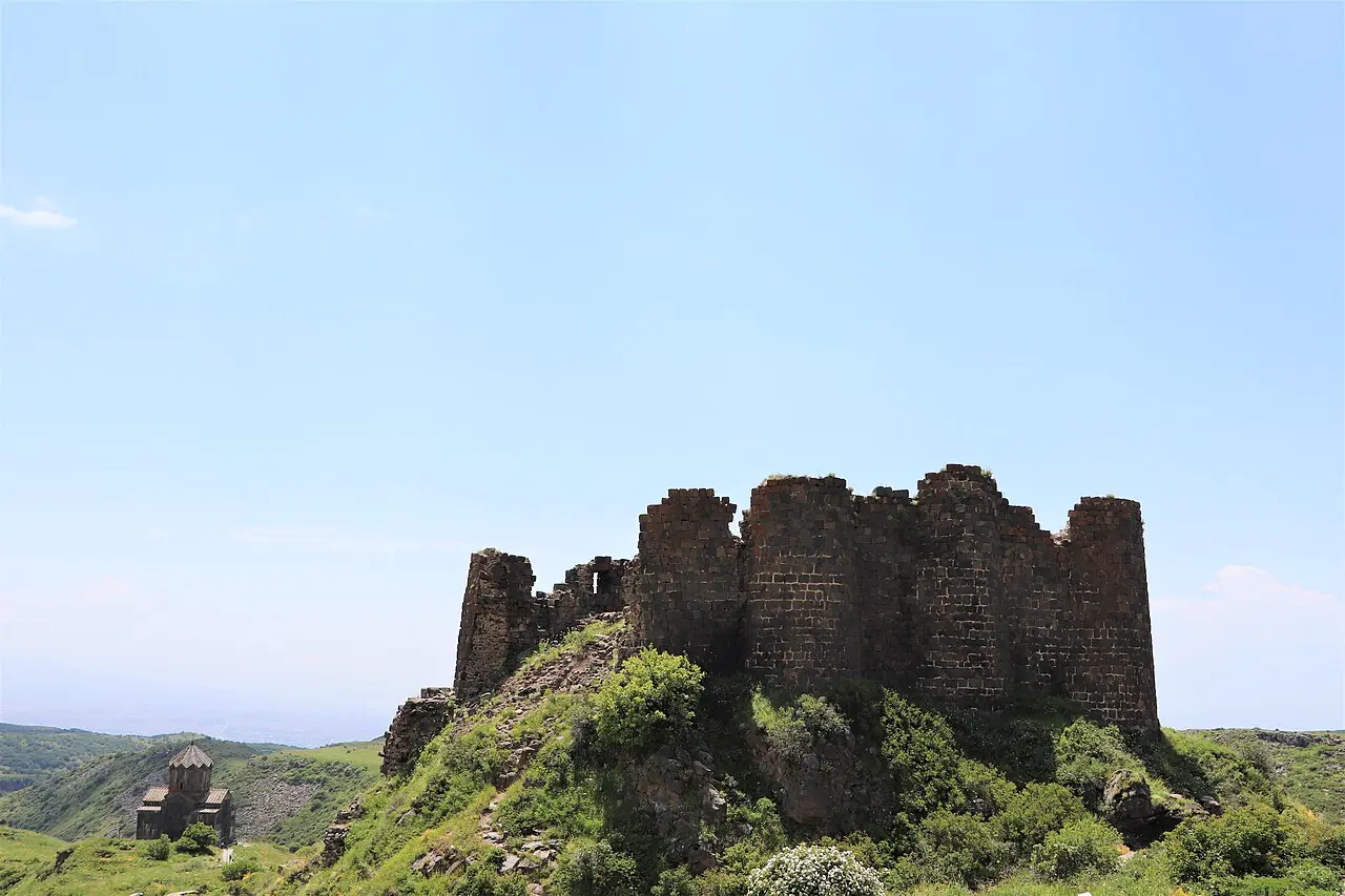 Amberd fortress on its green summer spur with the small stone Vahramashen church standing a little apart on the hillside