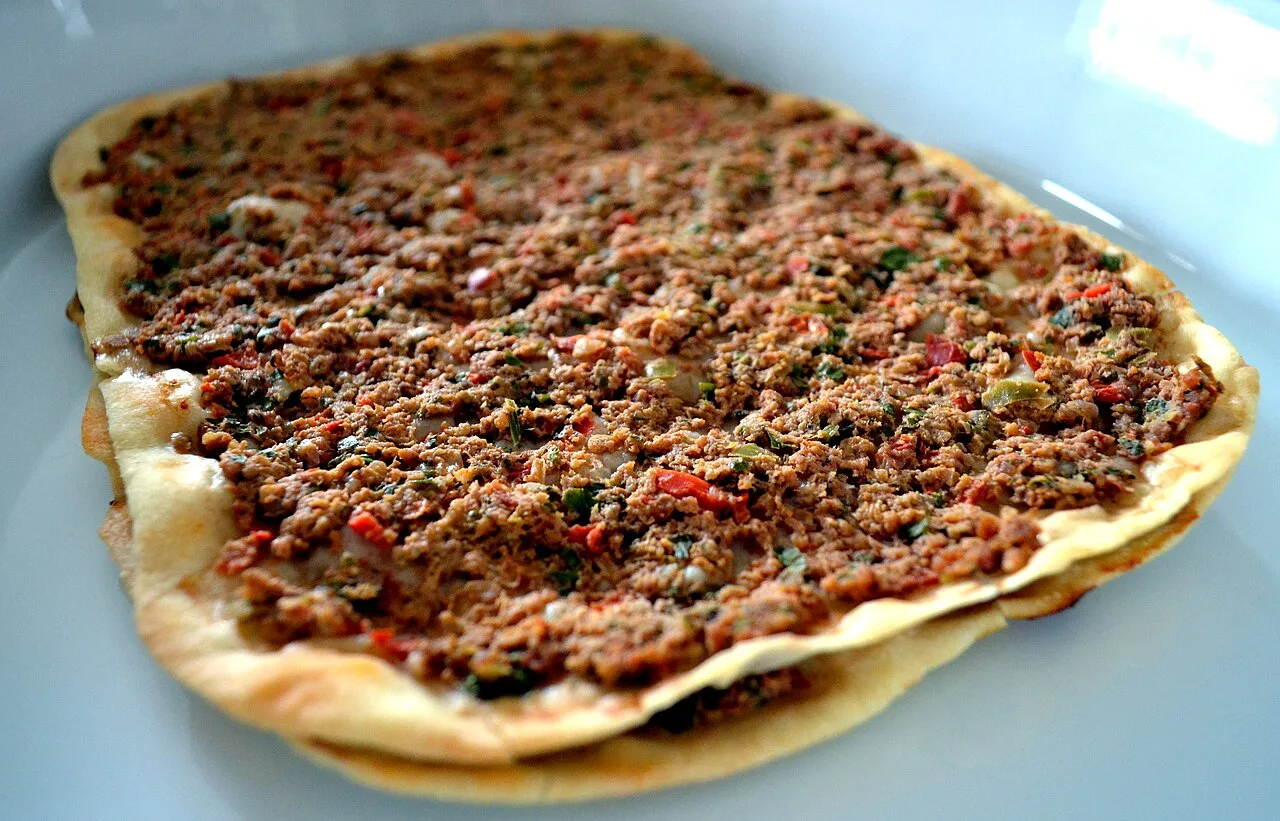 A round of Armenian lahmajo flatbread topped with minced meat and herbs