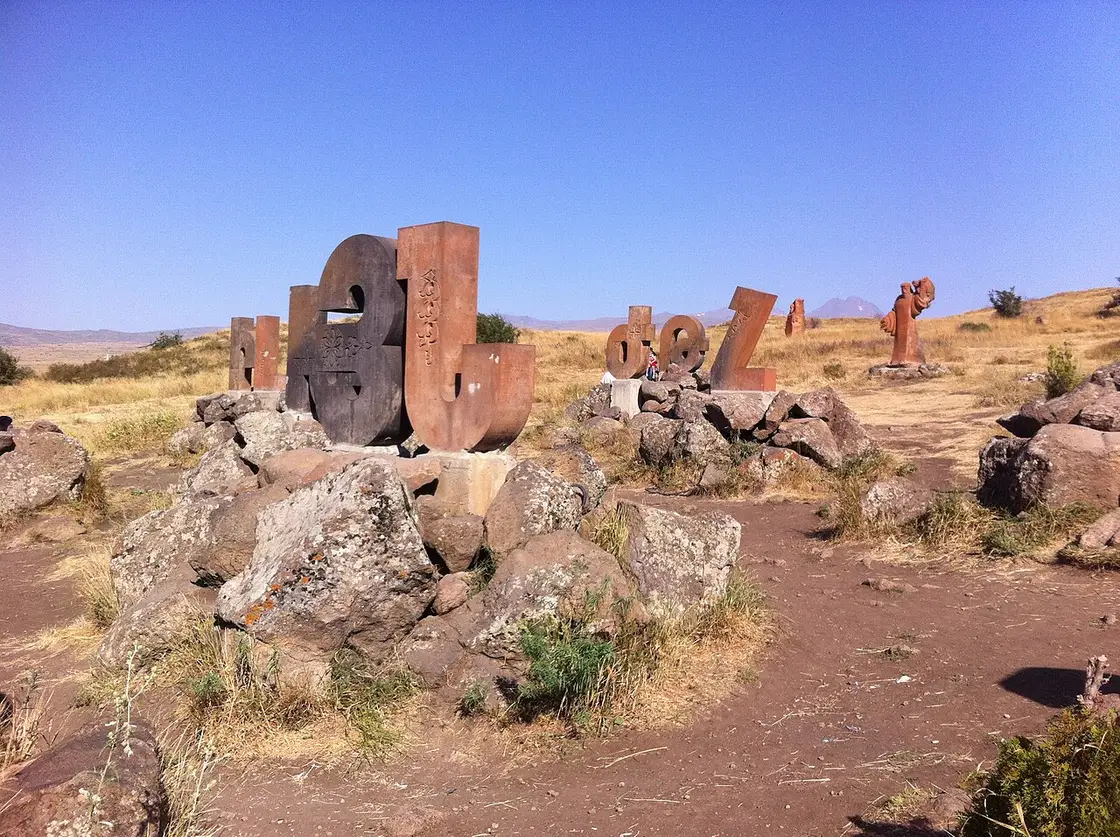 Giant carved stone letters of the Armenian alphabet standing in a field on the slopes of Mount Aragats