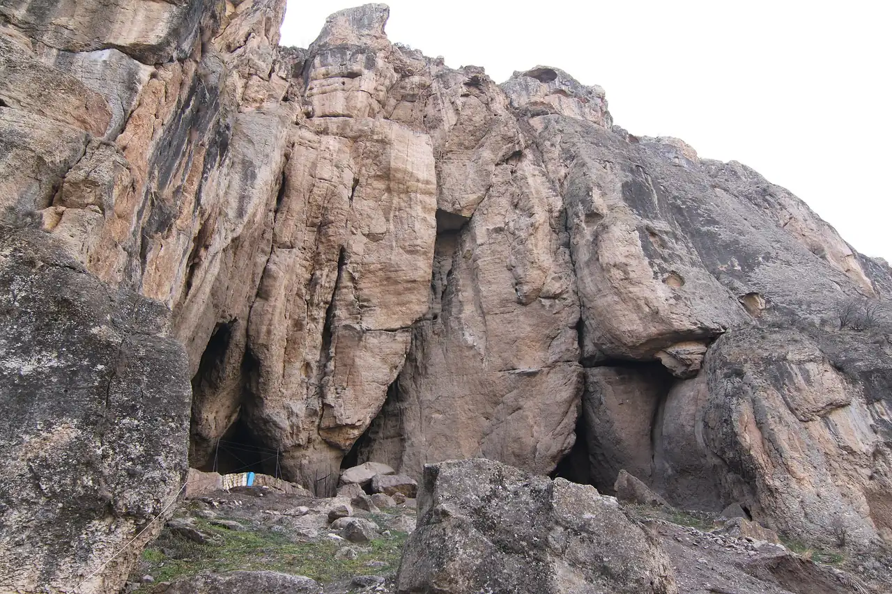 The tall pale cliff above Areni-1 cave in Vayots Dzor, with the cave openings at the base of the rock