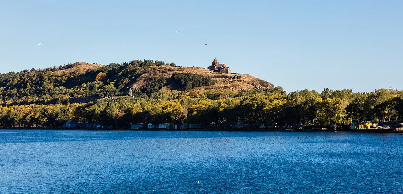 The dark churches of Sevanavank on their headland above the wide blue water of Lake Sevan