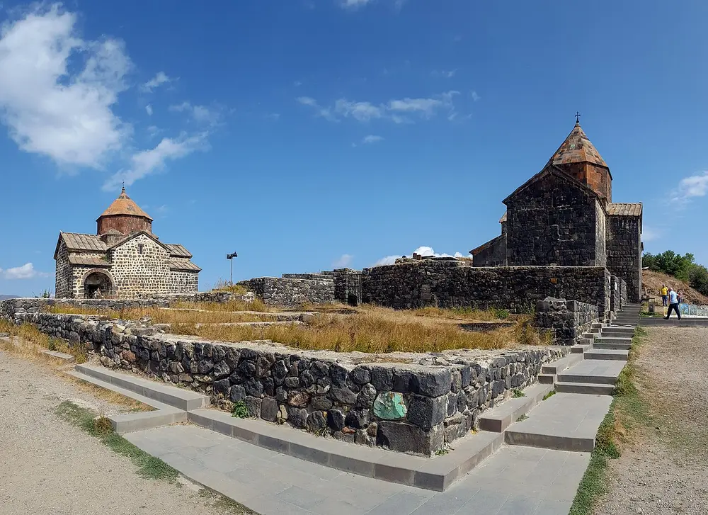 The dark basalt churches of Sevanavank above the blue water of Lake Sevan