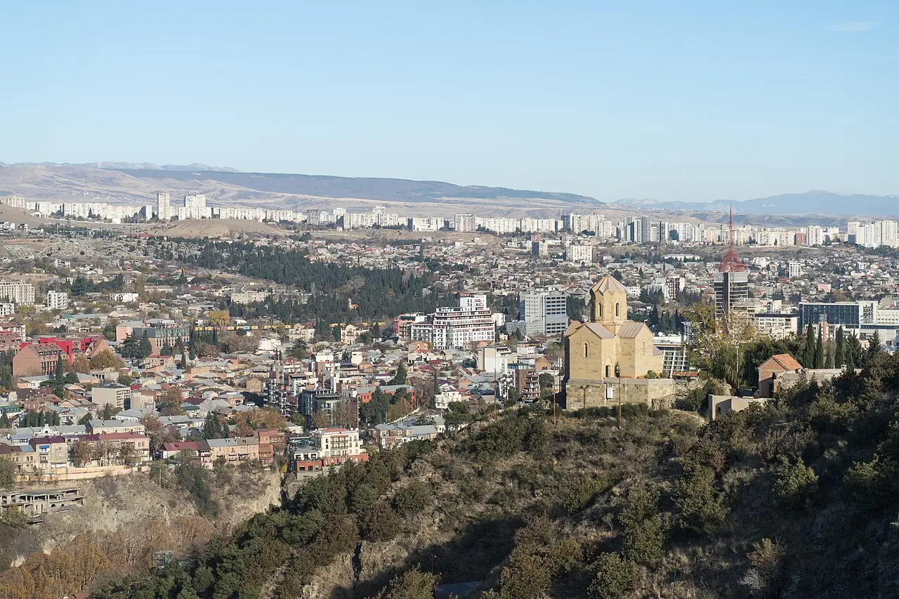A wide view over Tbilisi with the old town, church domes and the ridge of the Narikala fortress above the Mtkvari river
