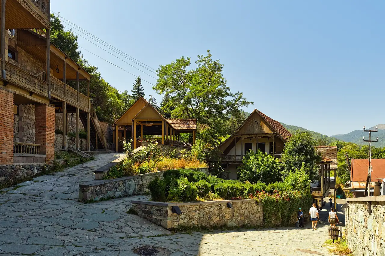 The cobbled Sharambeyan craft street in Dilijan with wooden balconies and green hills behind