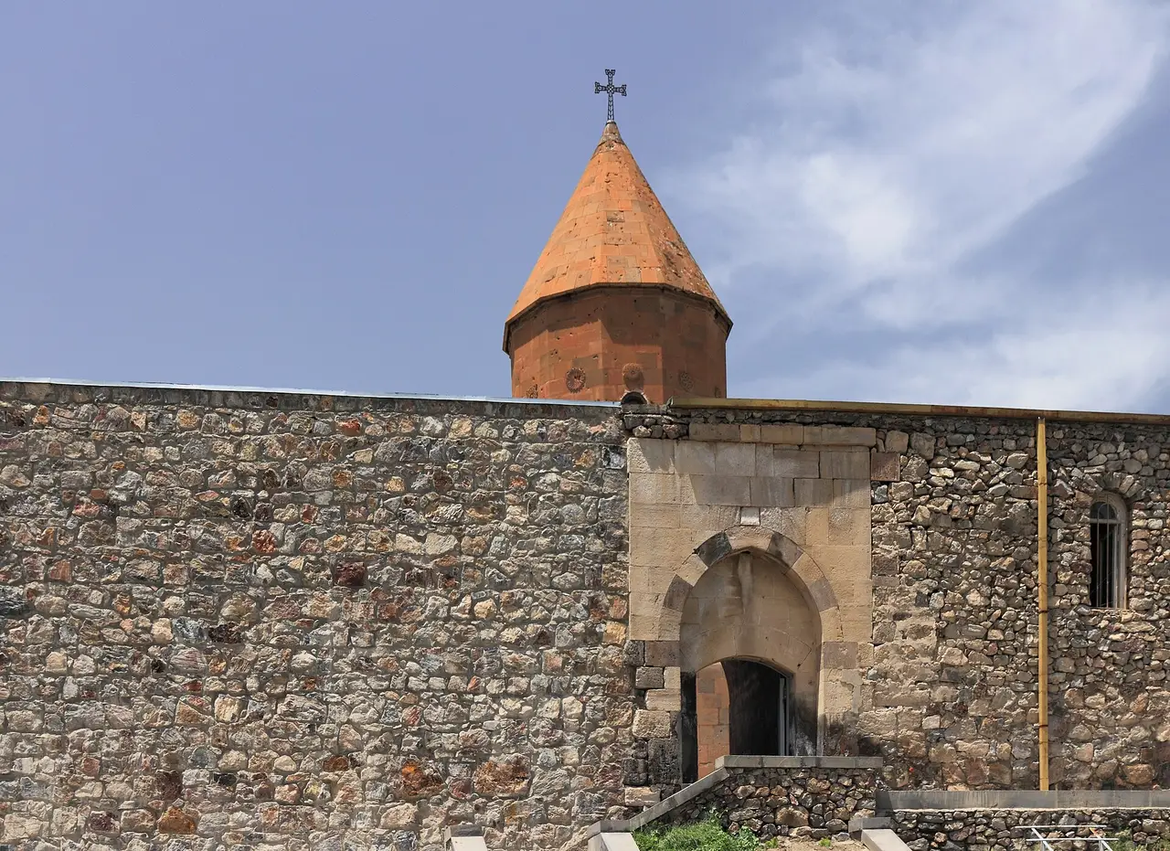 The orange-tuff church of Khor Virap rising behind the monastery grey stone wall and gate