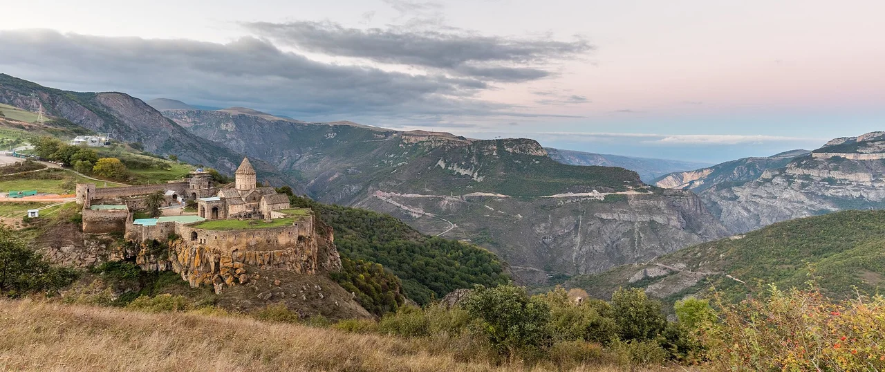 Tatev monastery on its plateau at the lip of the deep Vorotan gorge with ridges behind
