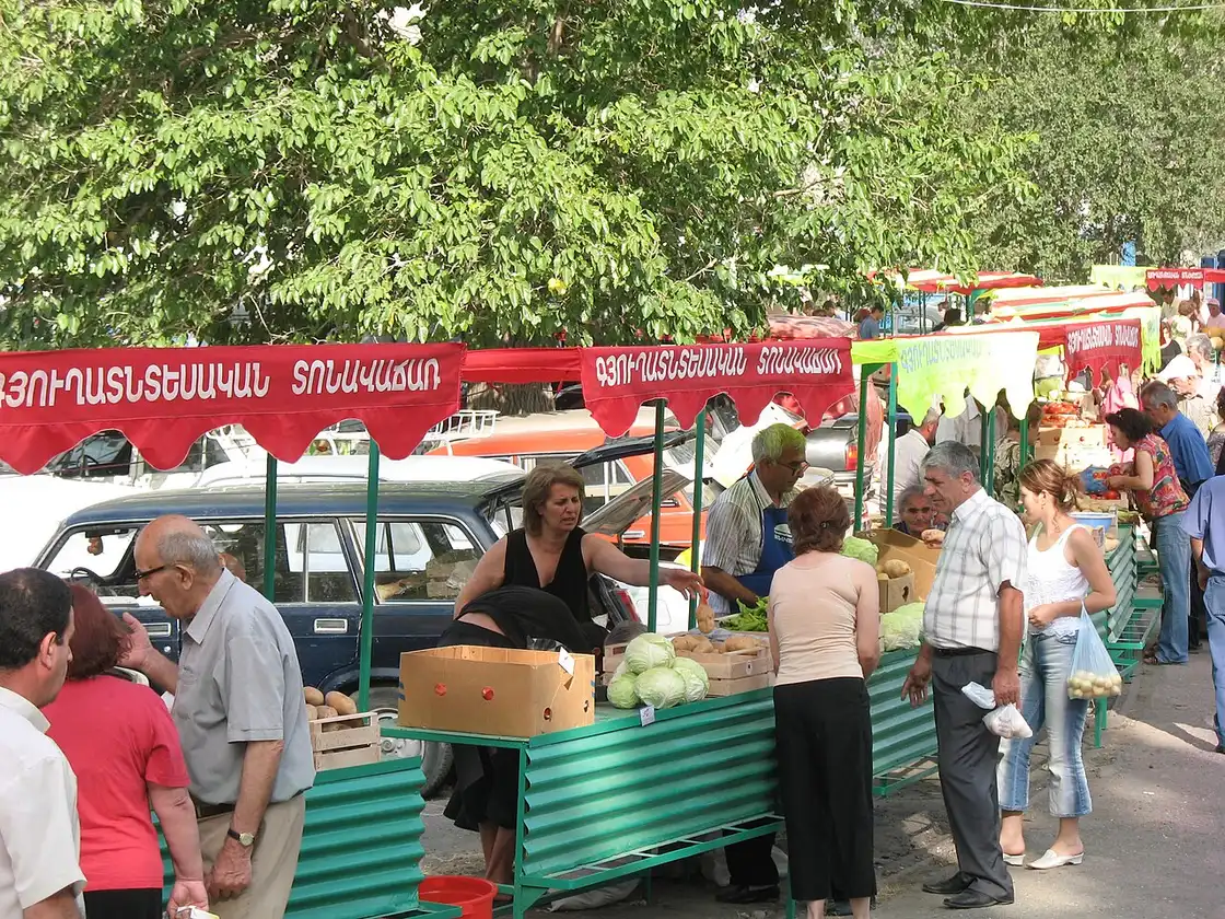 Trays of fruit and vegetables piled on tables at an outdoor agricultural bazaar in Armenia