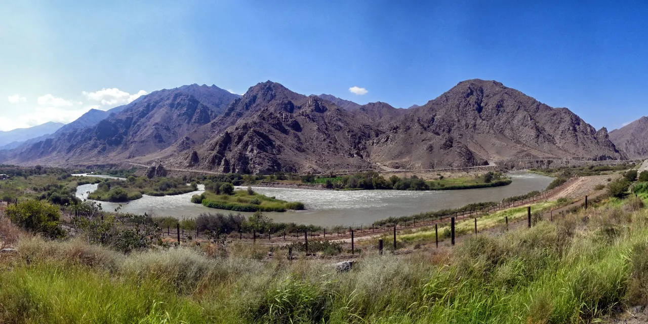 The Araks river winding between mountains at Meghri, with the border fence running along the Armenian bank