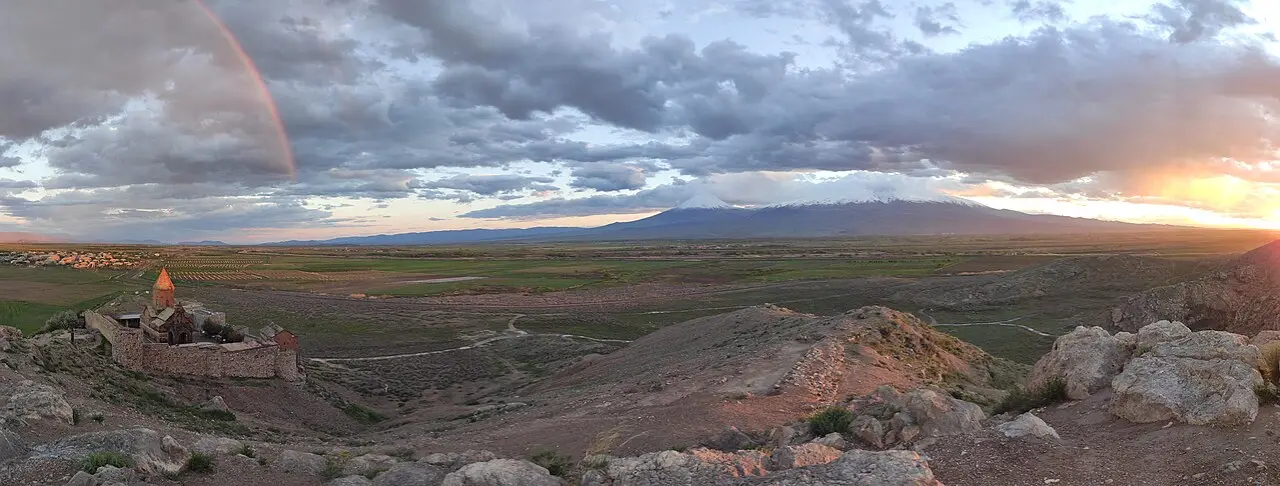 Khor Virap monastery on a low hill with the snow-capped double peak of Mount Ararat rising behind it