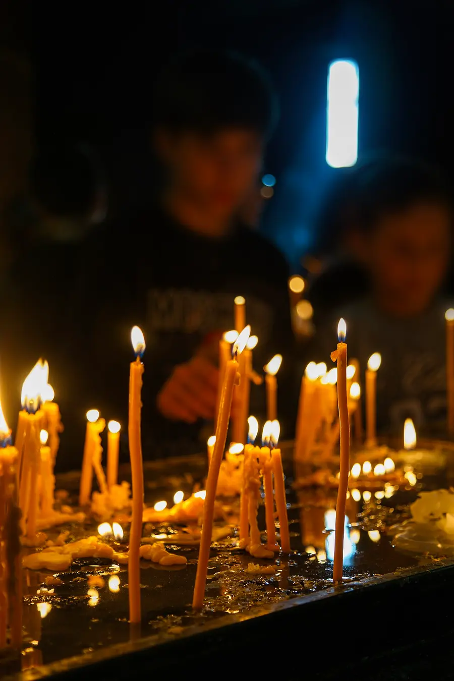 Rows of thin votive candles burning in the dim candle room of St Sarkis Cathedral in Yerevan