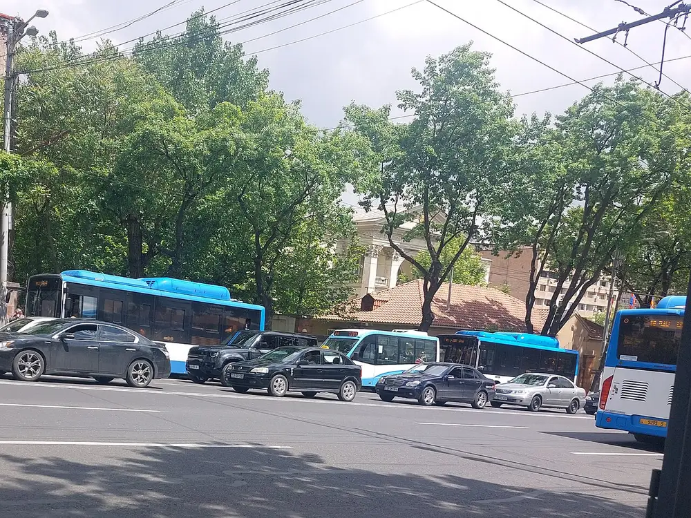 City buses and a GAZelle minibus waiting at a stop on a Yerevan street