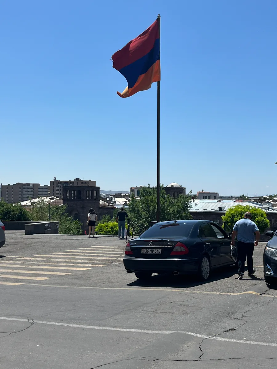 The red, blue and orange flag of Armenia flying against a blue sky in Yerevan