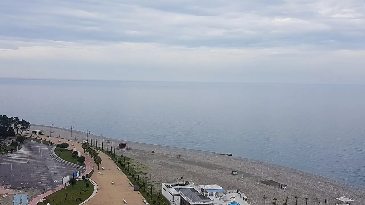 An aerial view of the Batumi seafront: the palm-lined boulevard, the long pebble beach and the Black Sea stretching to the horizon