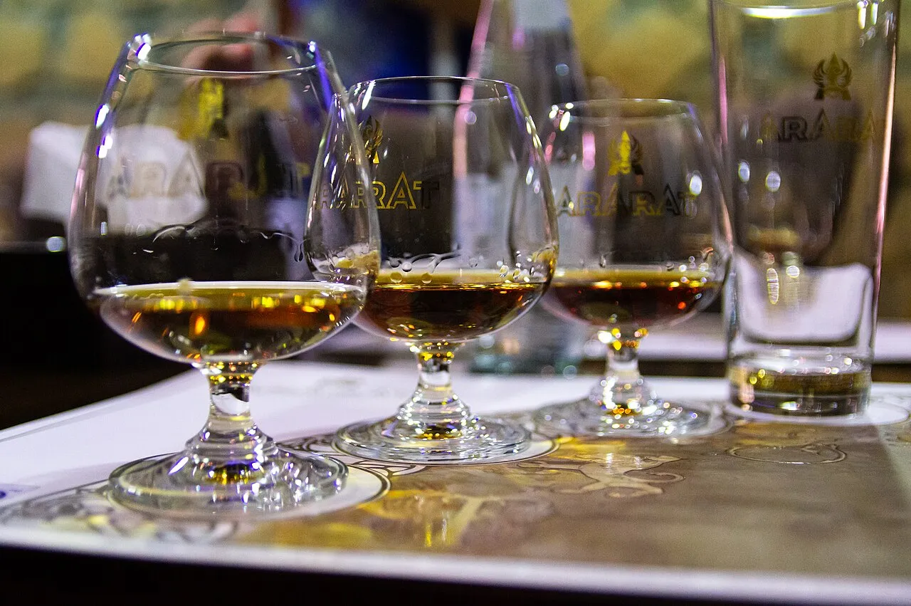 A glass and bottle of Armenian brandy on a table in Yerevan