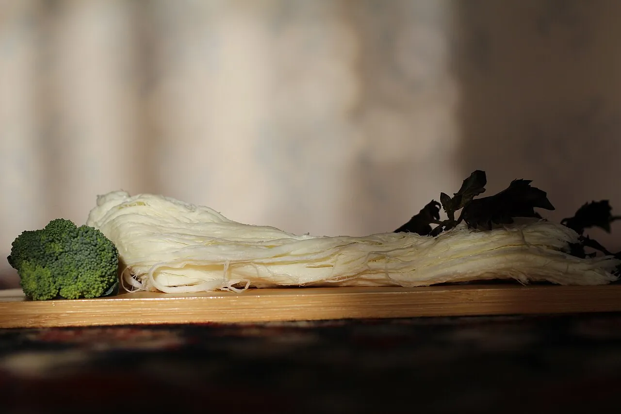 Braided strands of Armenian chechil string cheese on a board