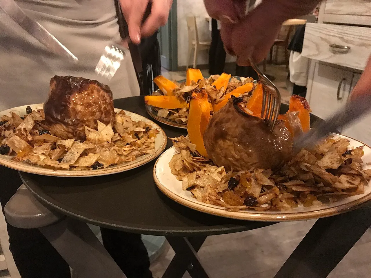 Gapama, a whole baked pumpkin stuffed with rice and dried fruit, sliced open on a plate