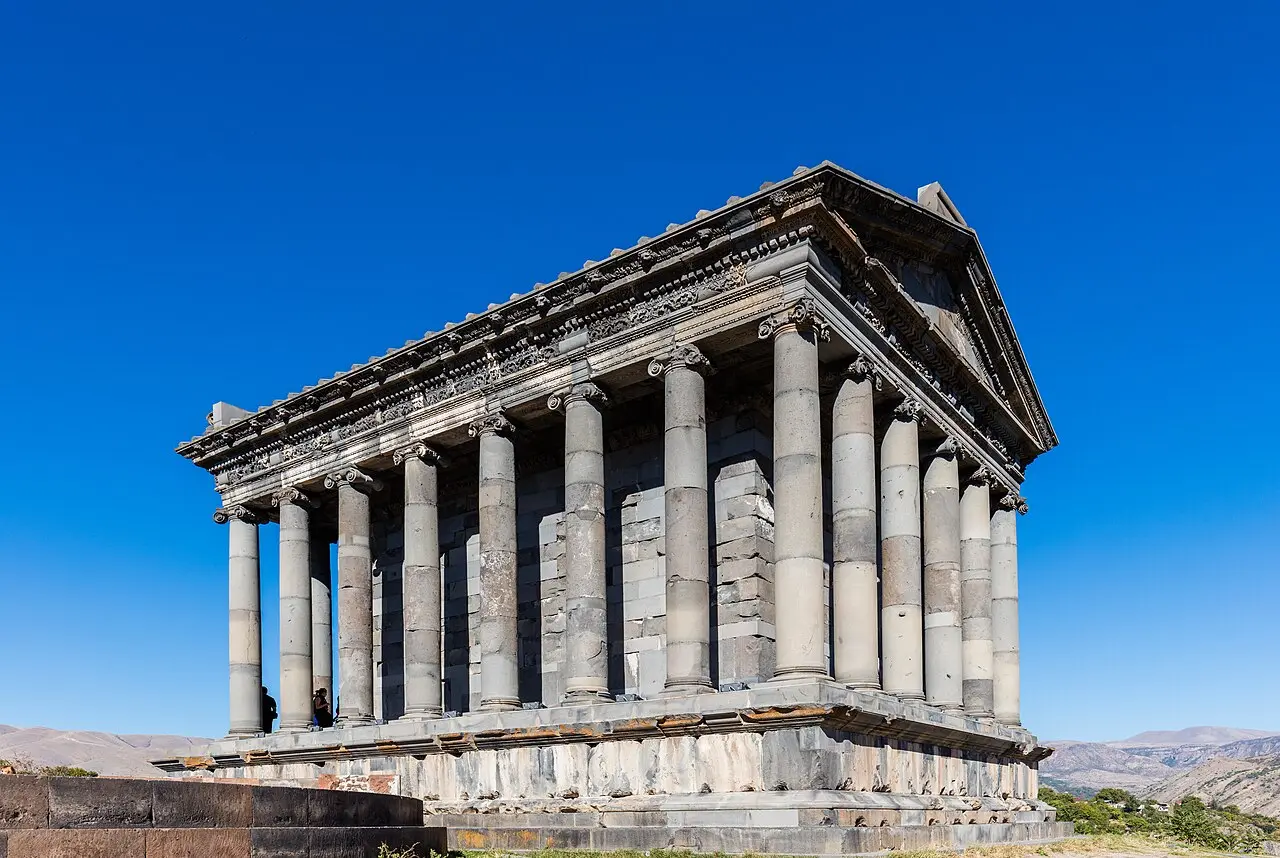 The colonnaded first-century Greco-Roman temple of Garni standing on a clifftop under a blue sky east of Yerevan