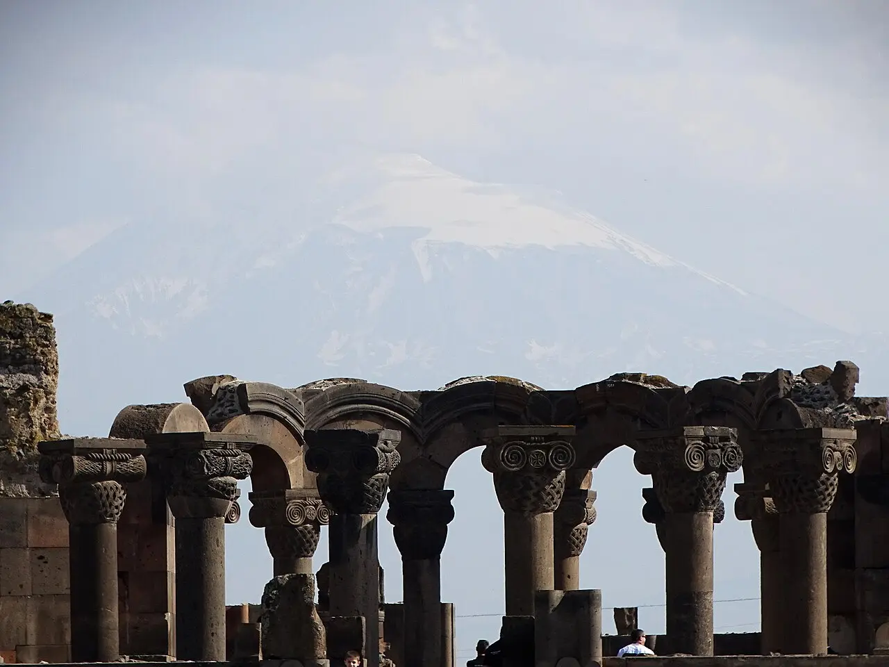 The circular ruins and standing columns of the 7th-century Zvartnots cathedral with Mount Ararat on the horizon