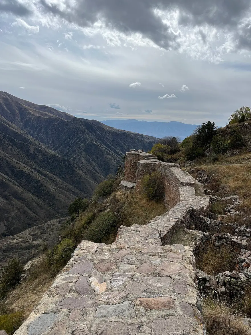 The restored stone walls of Smbataberd fortress running along a high ridge above the Yeghegis valley
