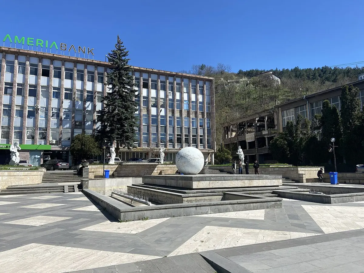 Dilijan town square with trees, shops and the Ameriabank building on a spring day