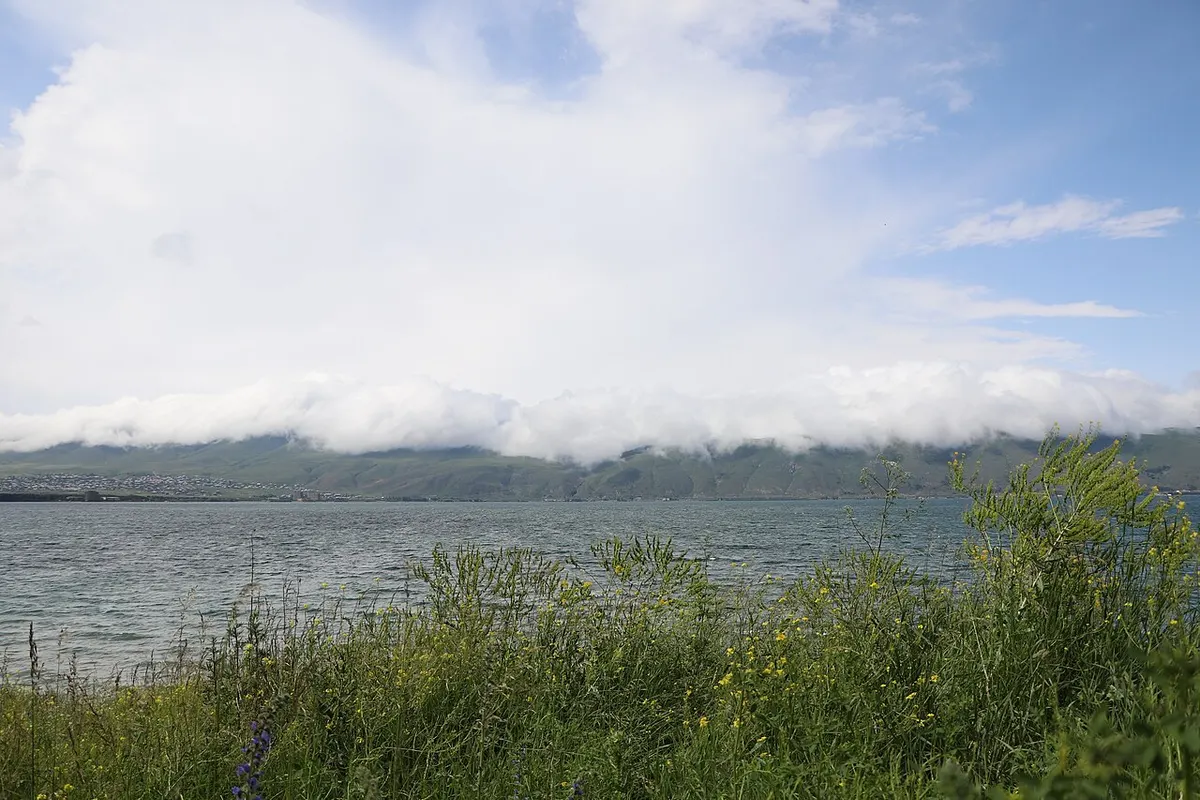 Blue water of Lake Sevan stretching to the mountains under a clear sky