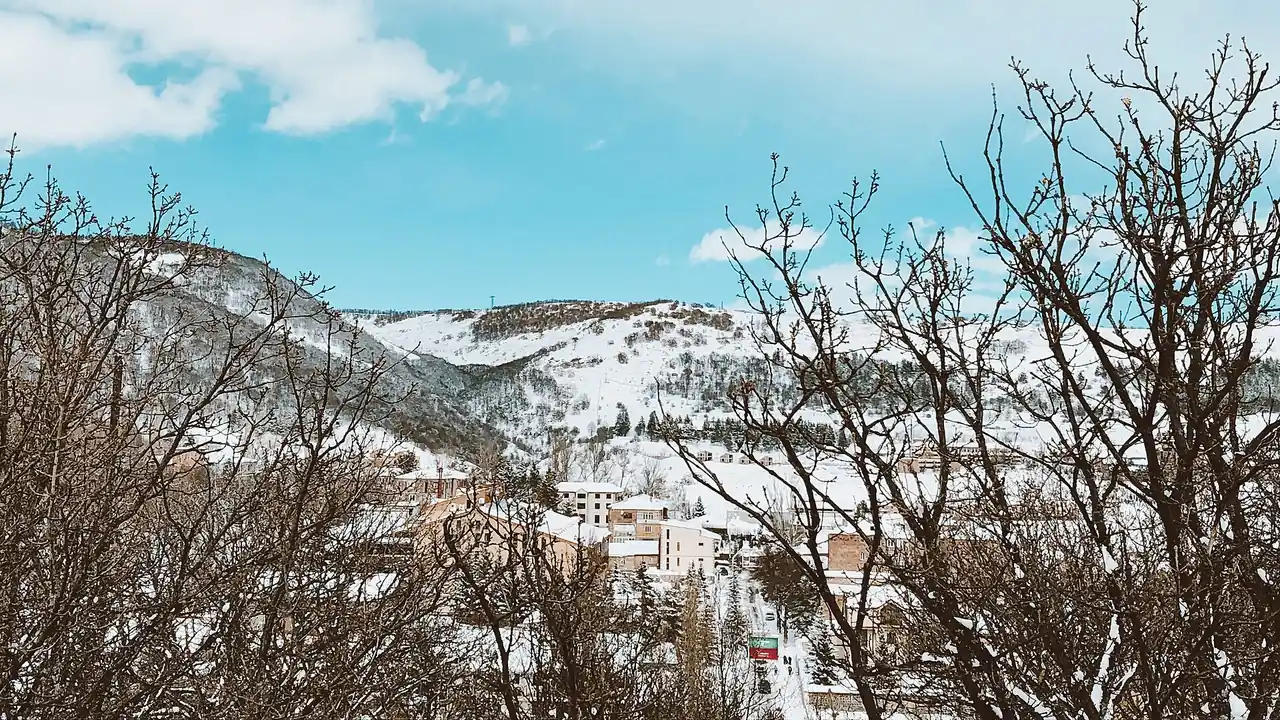 A snowy winter panorama of Tsaghkadzor with ski slopes on the mountainside and the resort town below