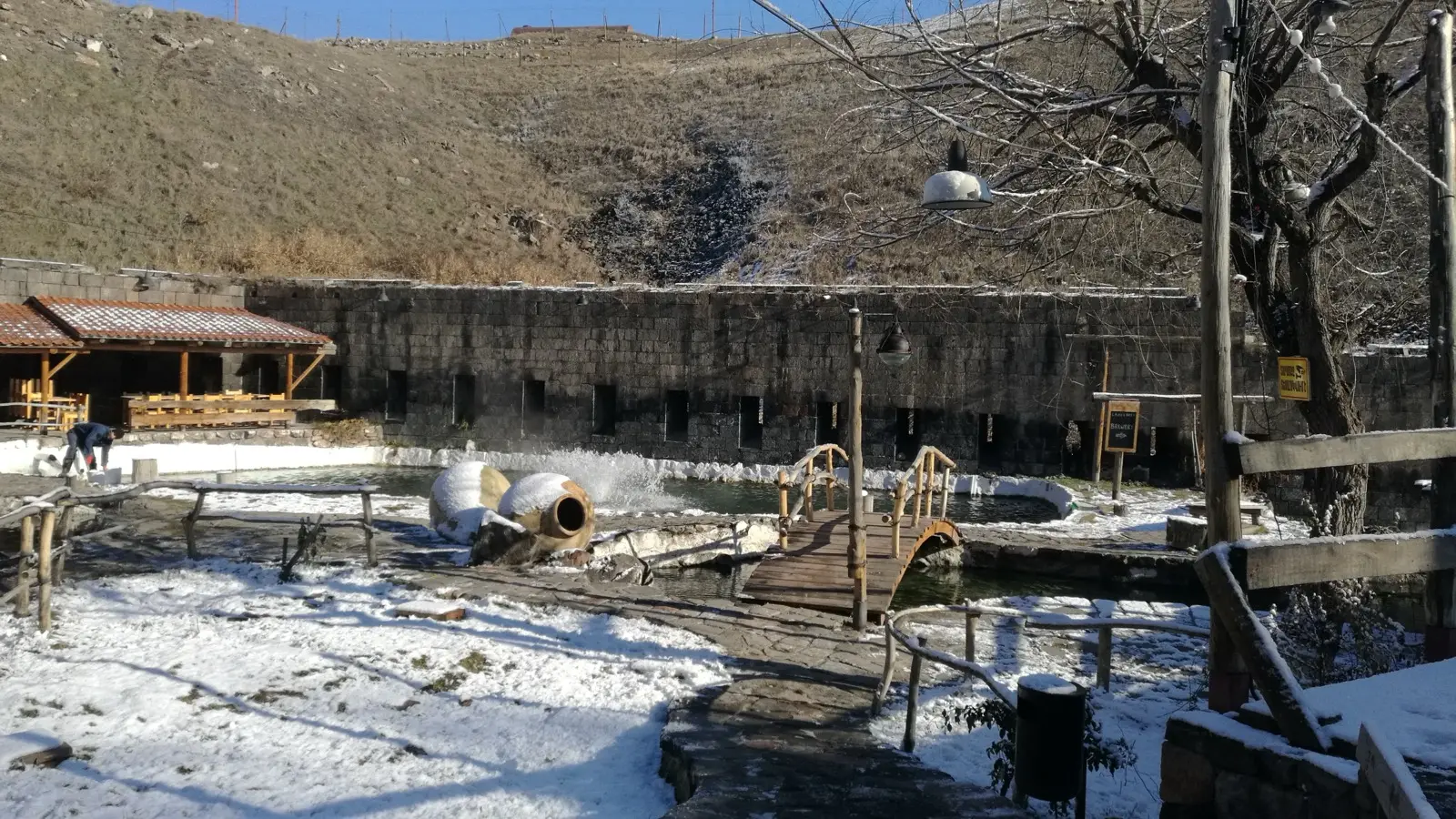 The Cherkezi Dzor trout farm and restaurant complex in a canyon on the edge of Gyumri, with clay wine jars and a wooden footbridge over the fish pools