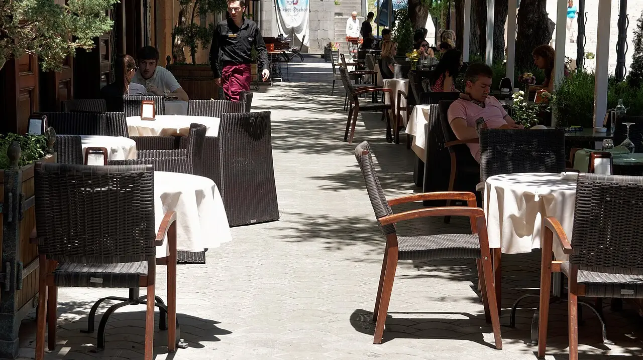 Crowded open-air cafe and restaurant terraces around Tamanyan Square below the Yerevan Cascade on a summer evening