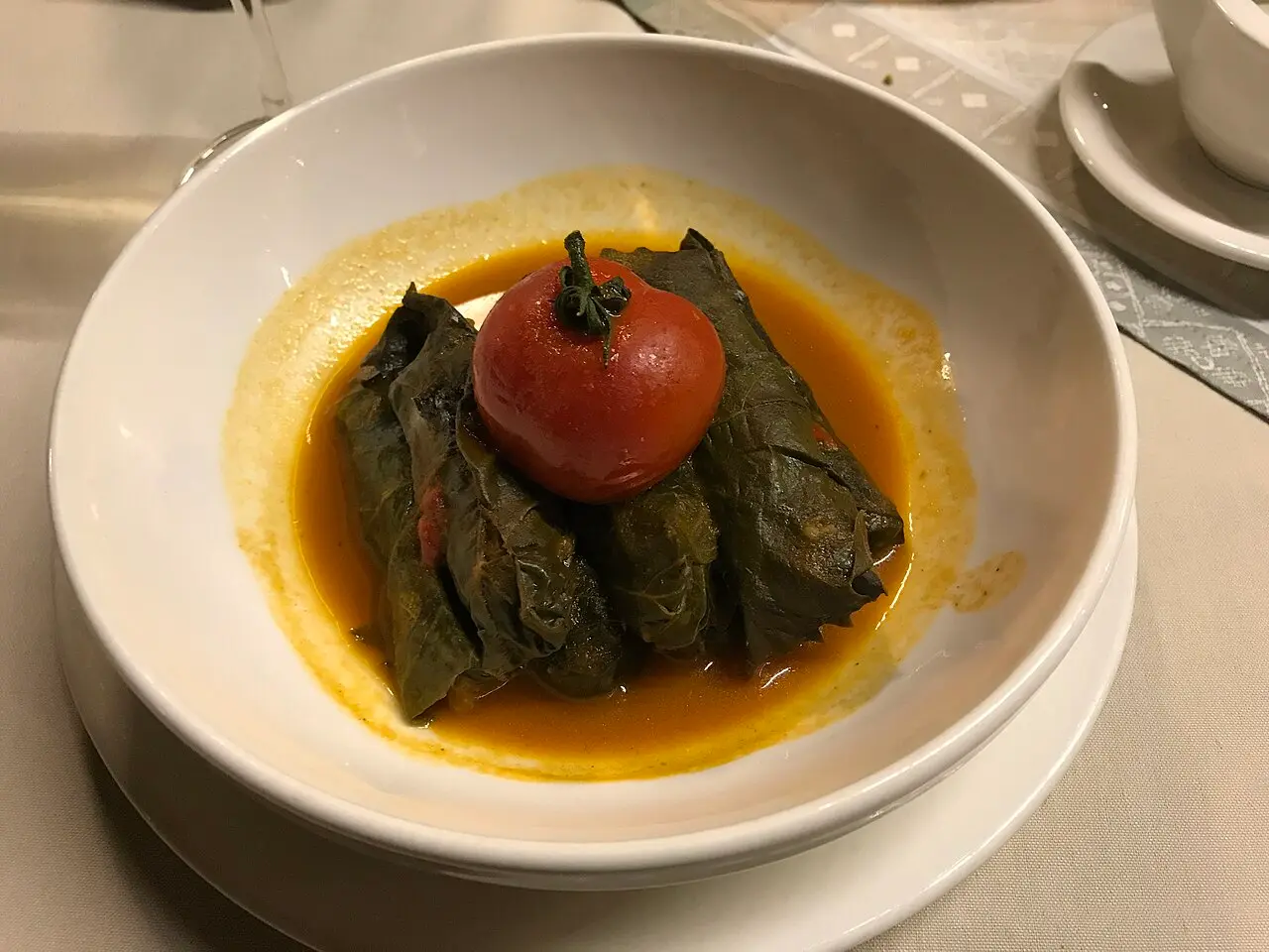 A plate of Armenian tolma, minced meat and rice wrapped in vine leaves, served with yogurt at a Yerevan restaurant