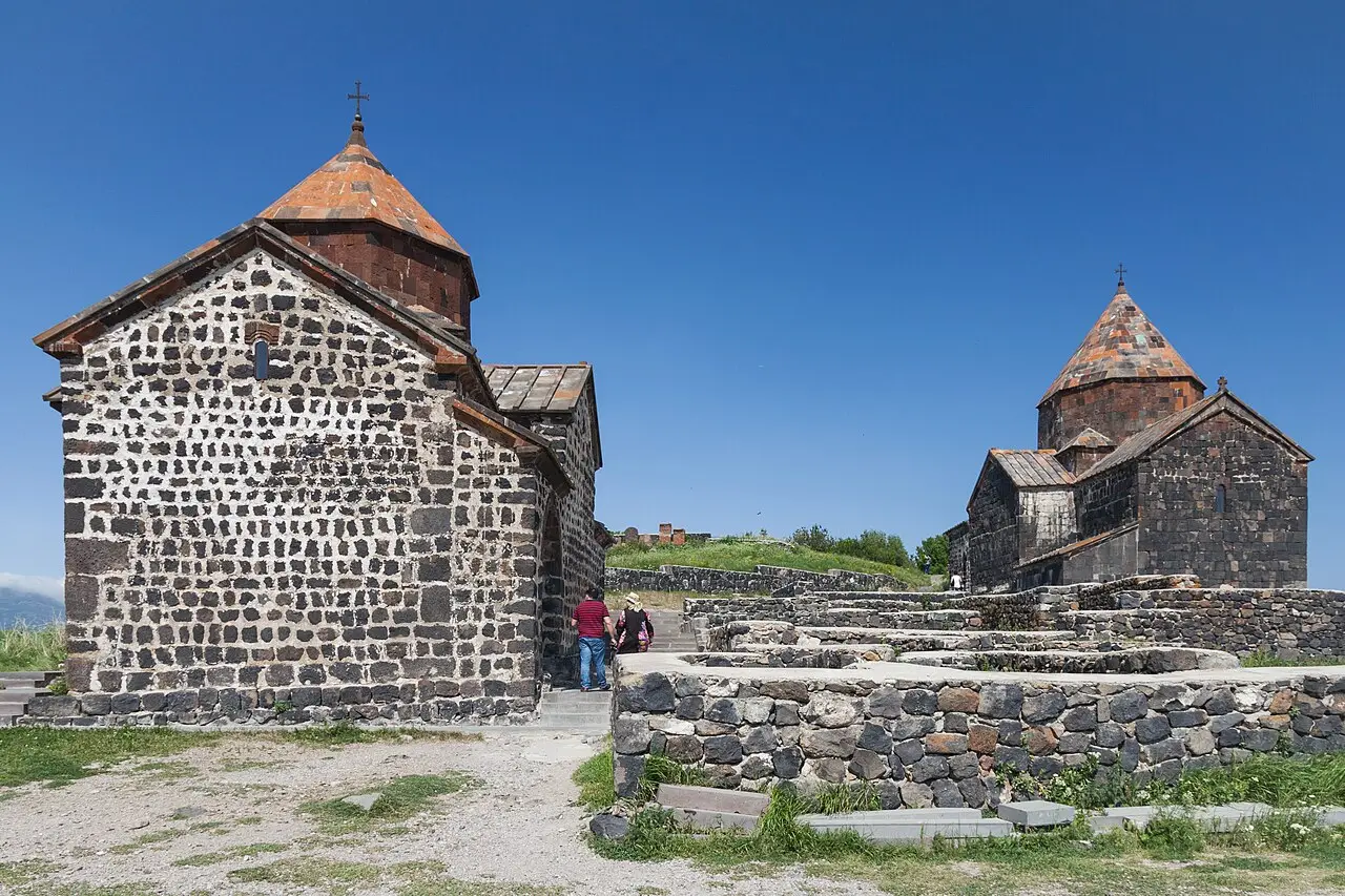 The blue water of Lake Sevan with the Sevanavank churches on their headland on a bright day