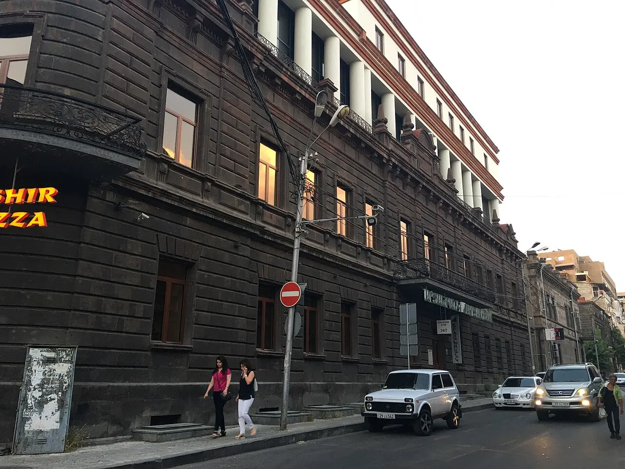 A mid-rise residential and office building on a leafy street in central Yerevan