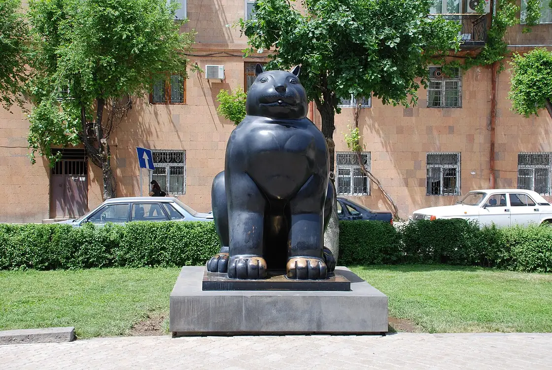 Fernando Botero bronze cat sculpture standing on a stone plinth in the Cafesjian Sculpture Garden at the foot of the Cascade