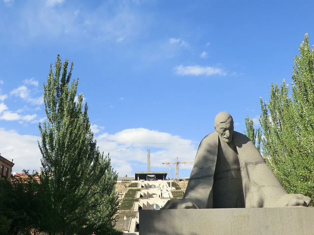 Bronze statue of architect Alexander Tamanyan bent over a drawing board at the foot of the Yerevan Cascade