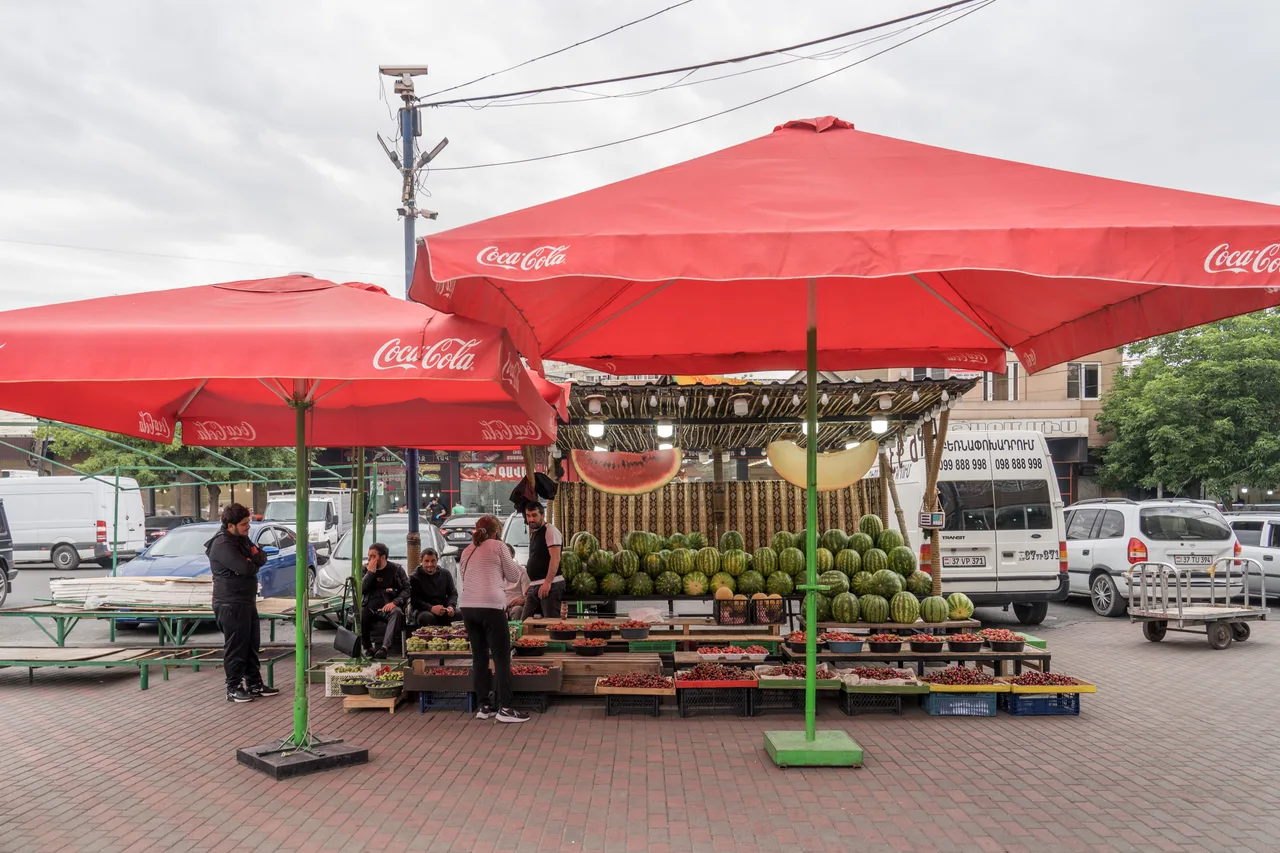 A vendor selling watermelons and summer fruit at the GUM produce market in Yerevan