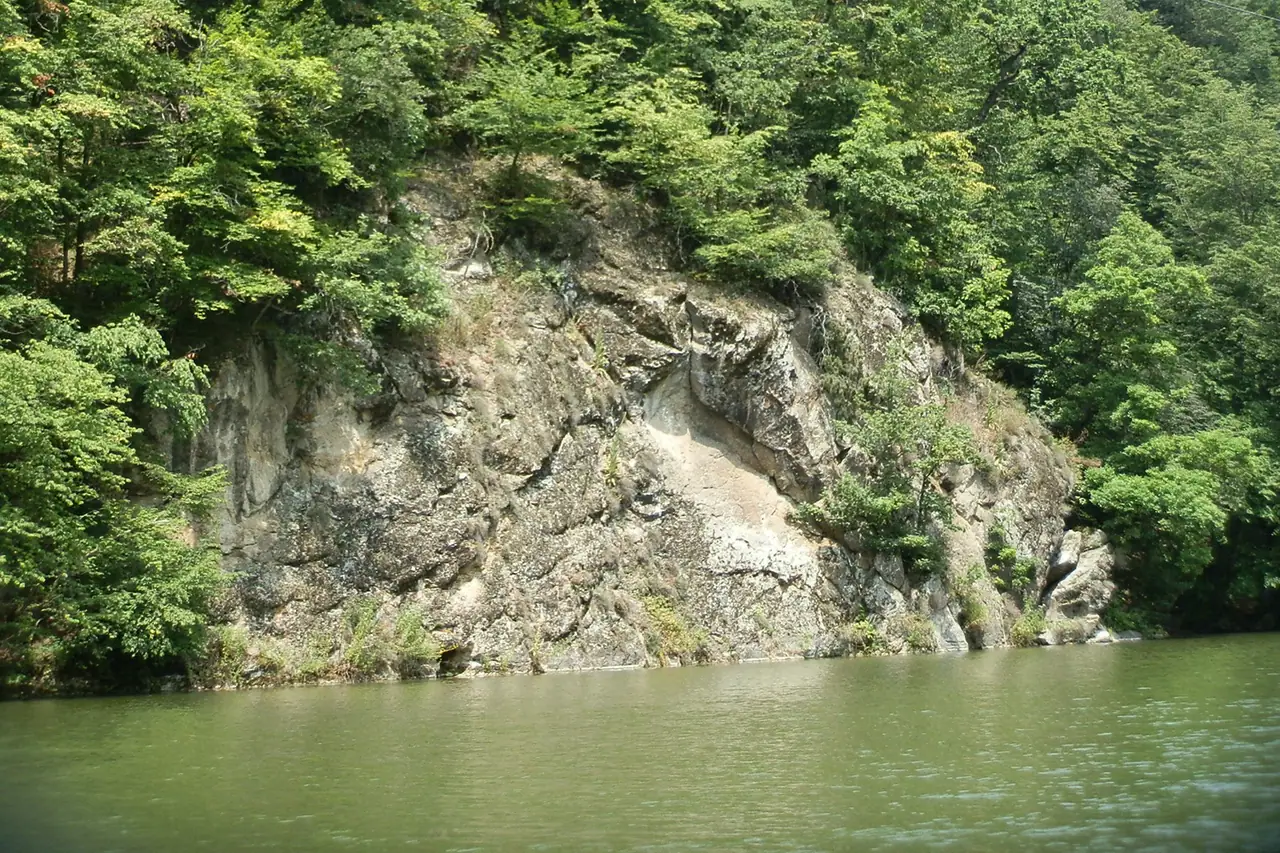 Still green water of Parz Lake ringed by beech forest in Dilijan National Park