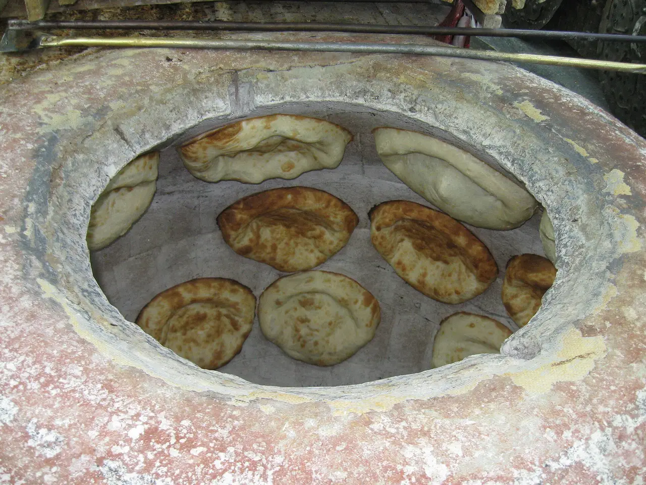 Rounds of bread baking against the clay wall of a tonir oven at the Gntunik bakery in Aparan