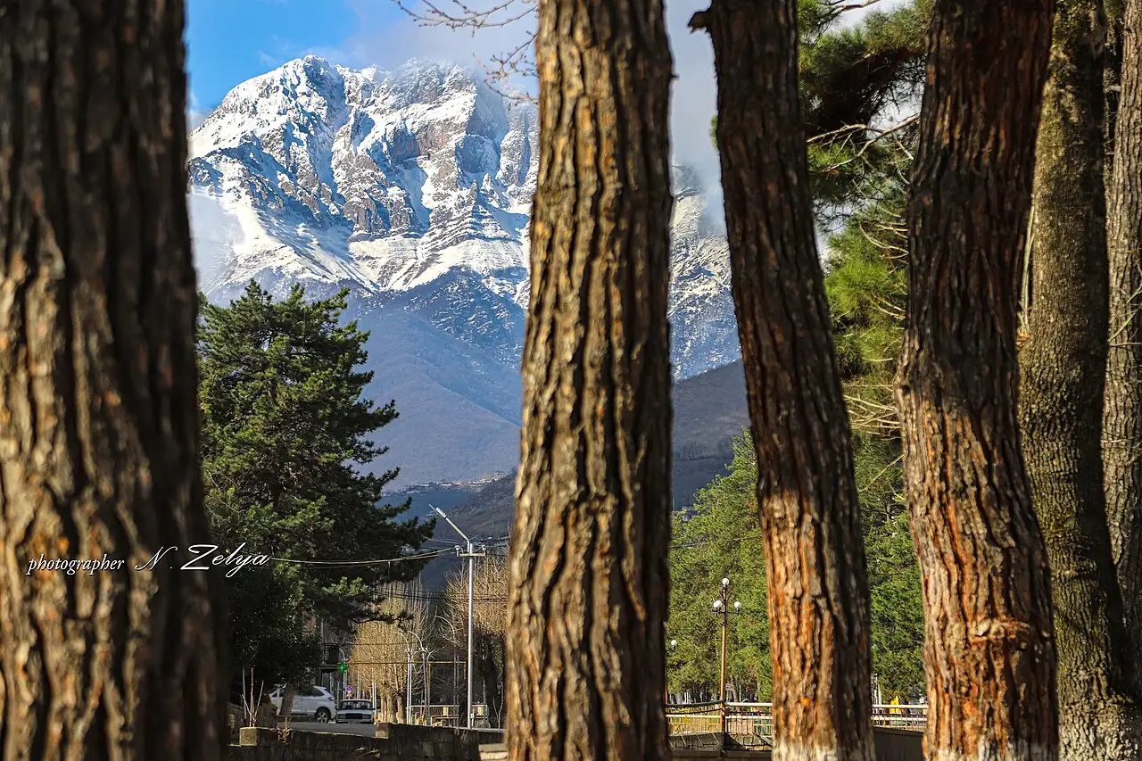 The town of Kapan spread in a green mountain valley with Mount Khustup rising behind
