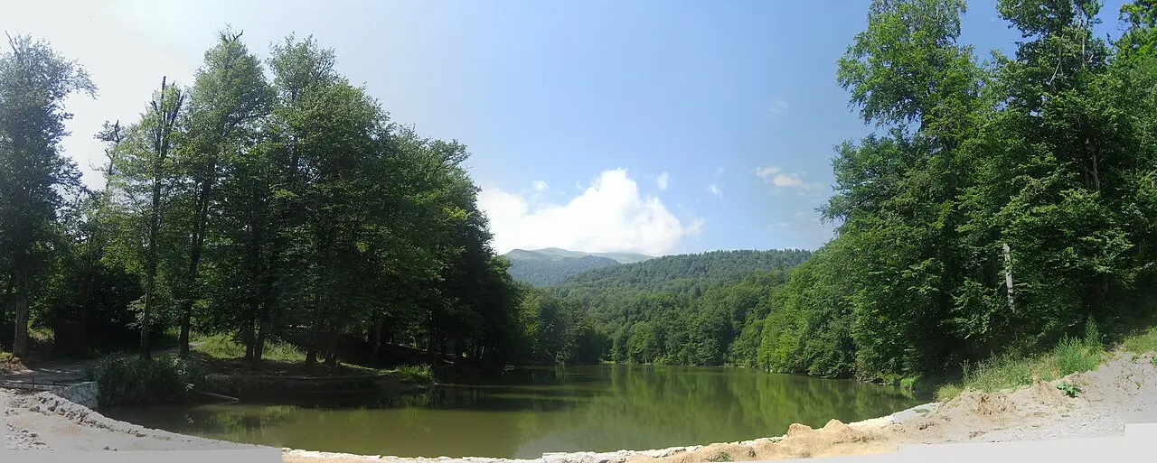 The still green water of Parz Lake ringed by forested slopes in Dilijan National Park