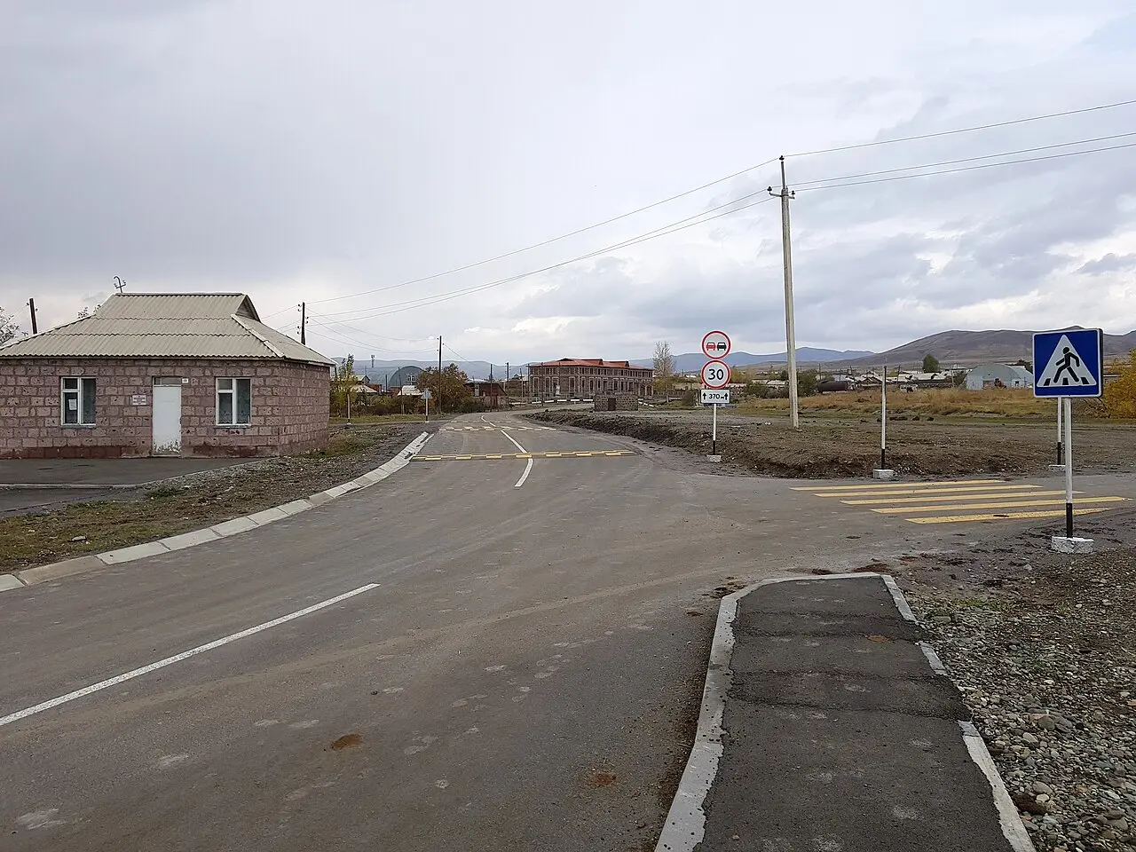 A quiet paved road running through a small village in the Shirak Province of Armenia