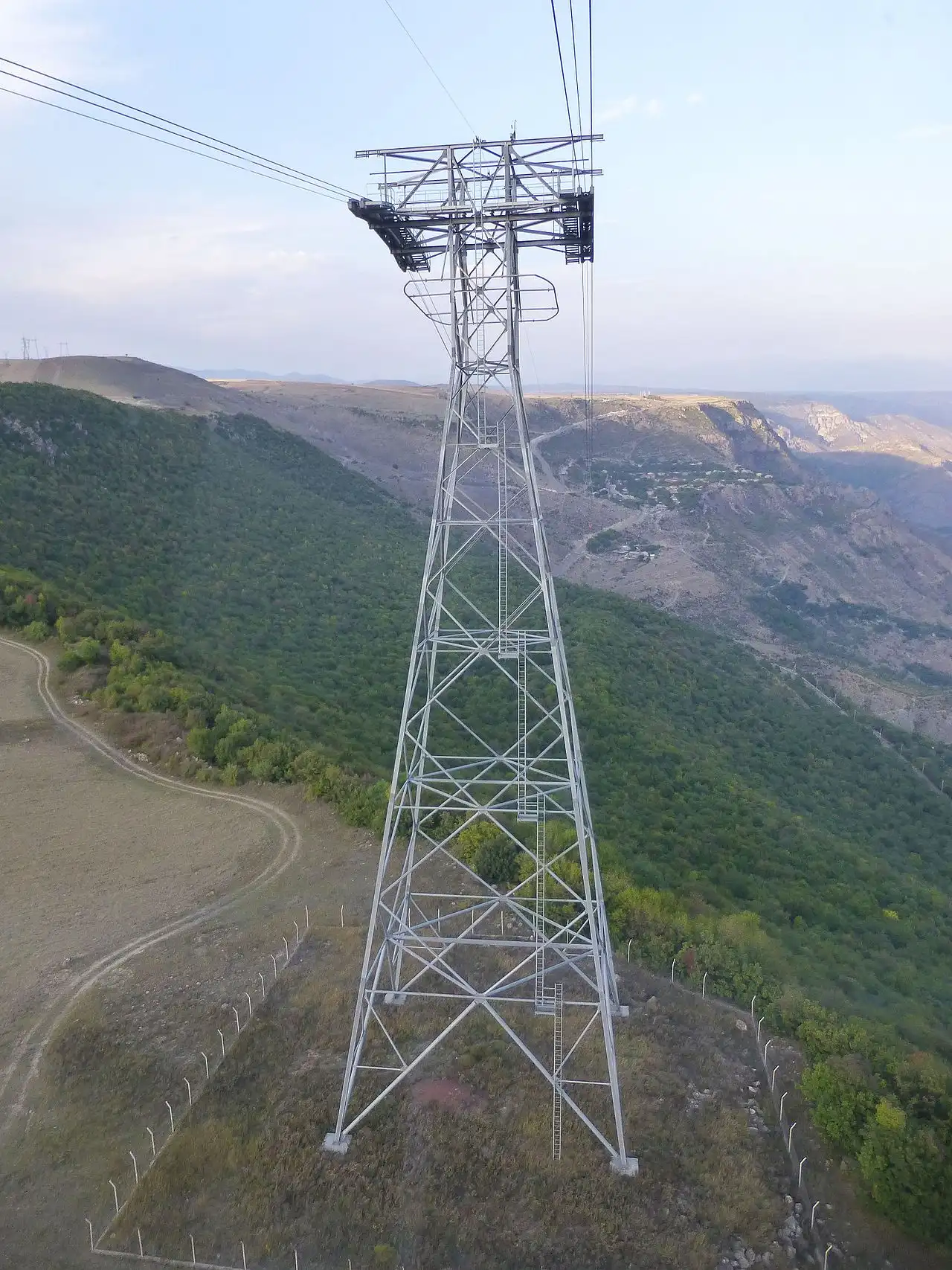 A steel pylon of the Wings of Tatev cable car towering over a forested gorge in southern Armenia