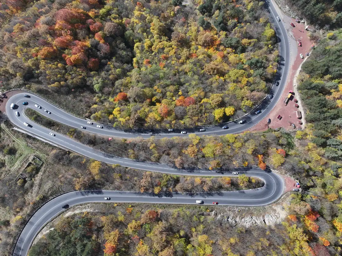 The M4 highway seen from above winding through dense autumn forest near Dilijan in northern Armenia
