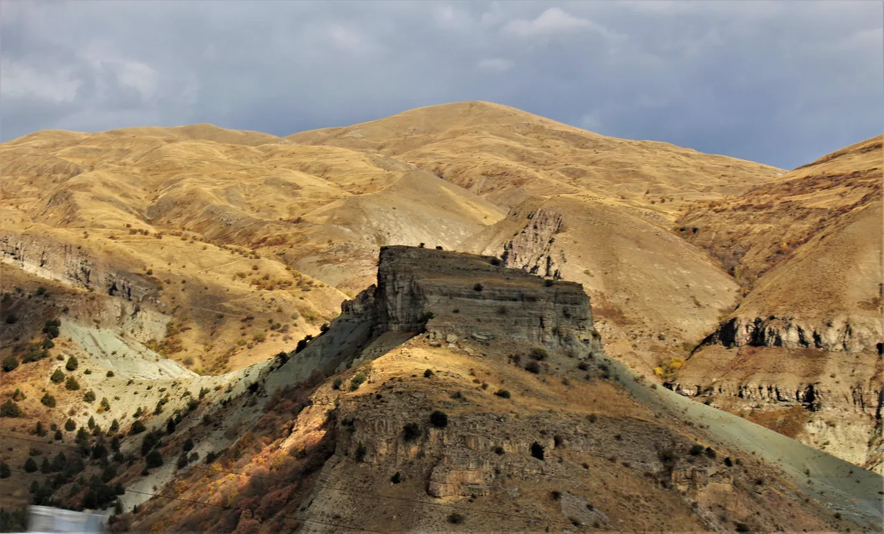 A paved road climbing in tight hairpin bends over the grassy Selim (Vardenyats) pass in Armenia