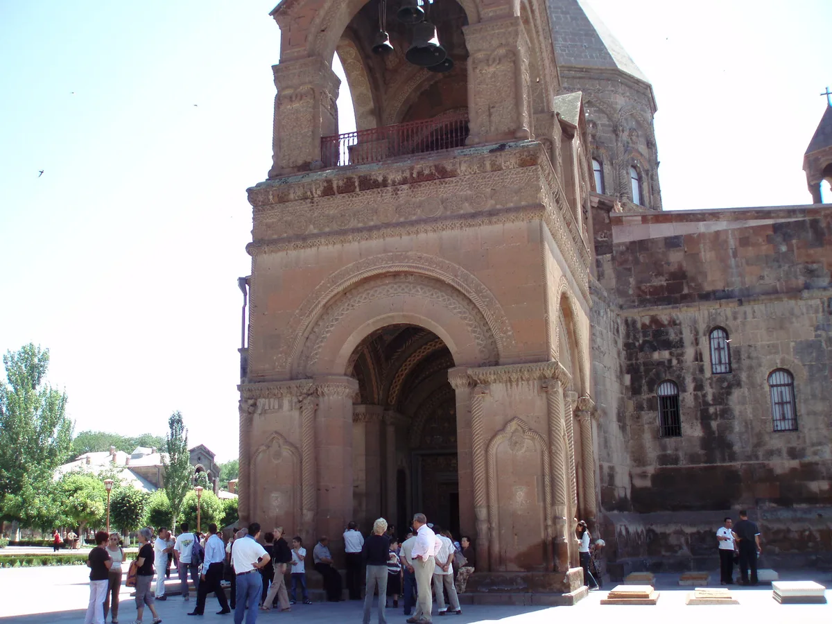 The main gate and bell tower of the Mother See of Holy Etchmiadzin with pilgrims in the courtyard