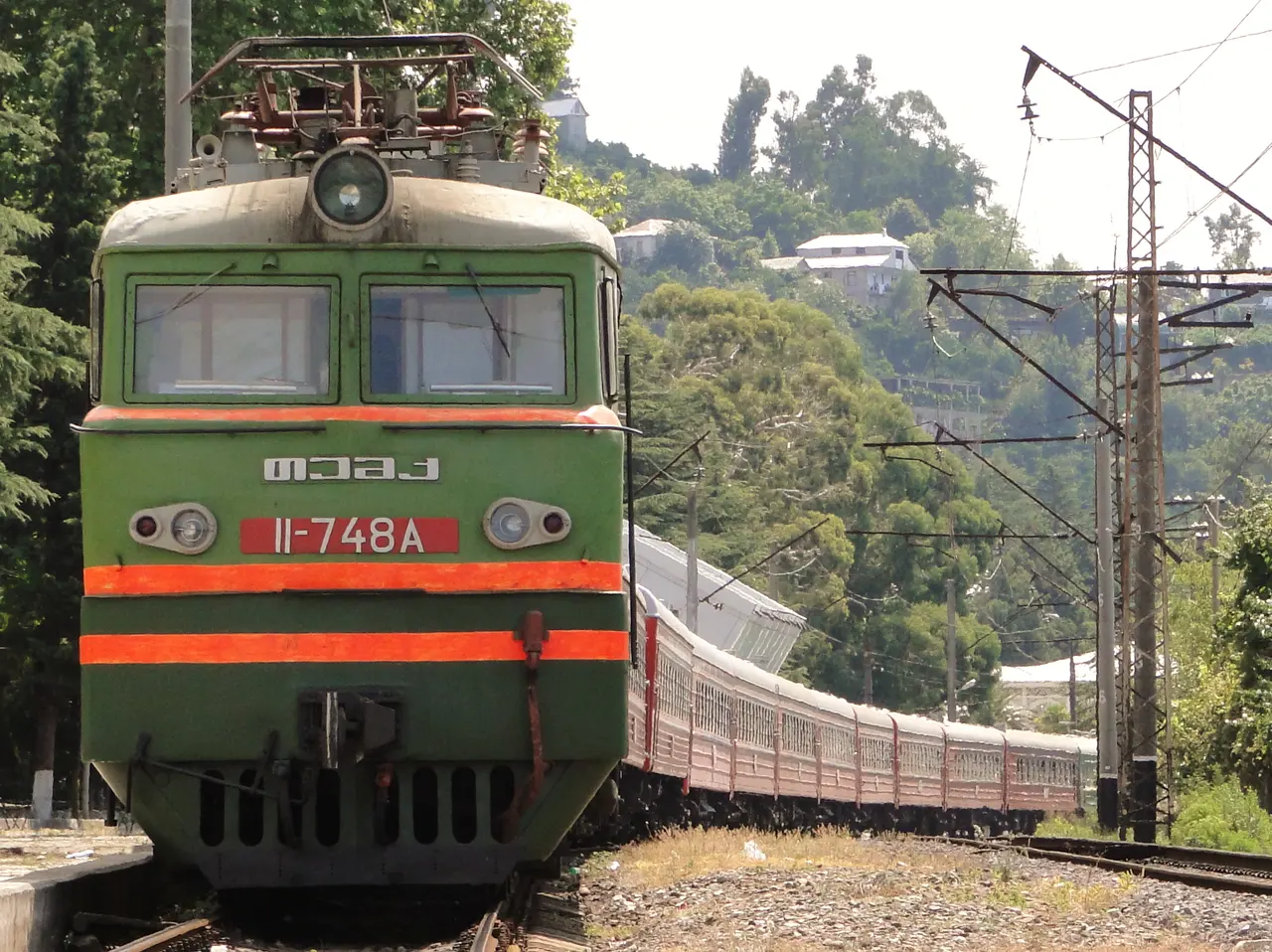 The green carriages of the Batumi to Yerevan international train standing at a platform