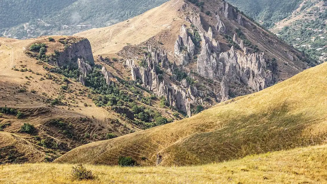 The eroded rock cones and cave dwellings above Goris, with the town in the valley below and hills behind