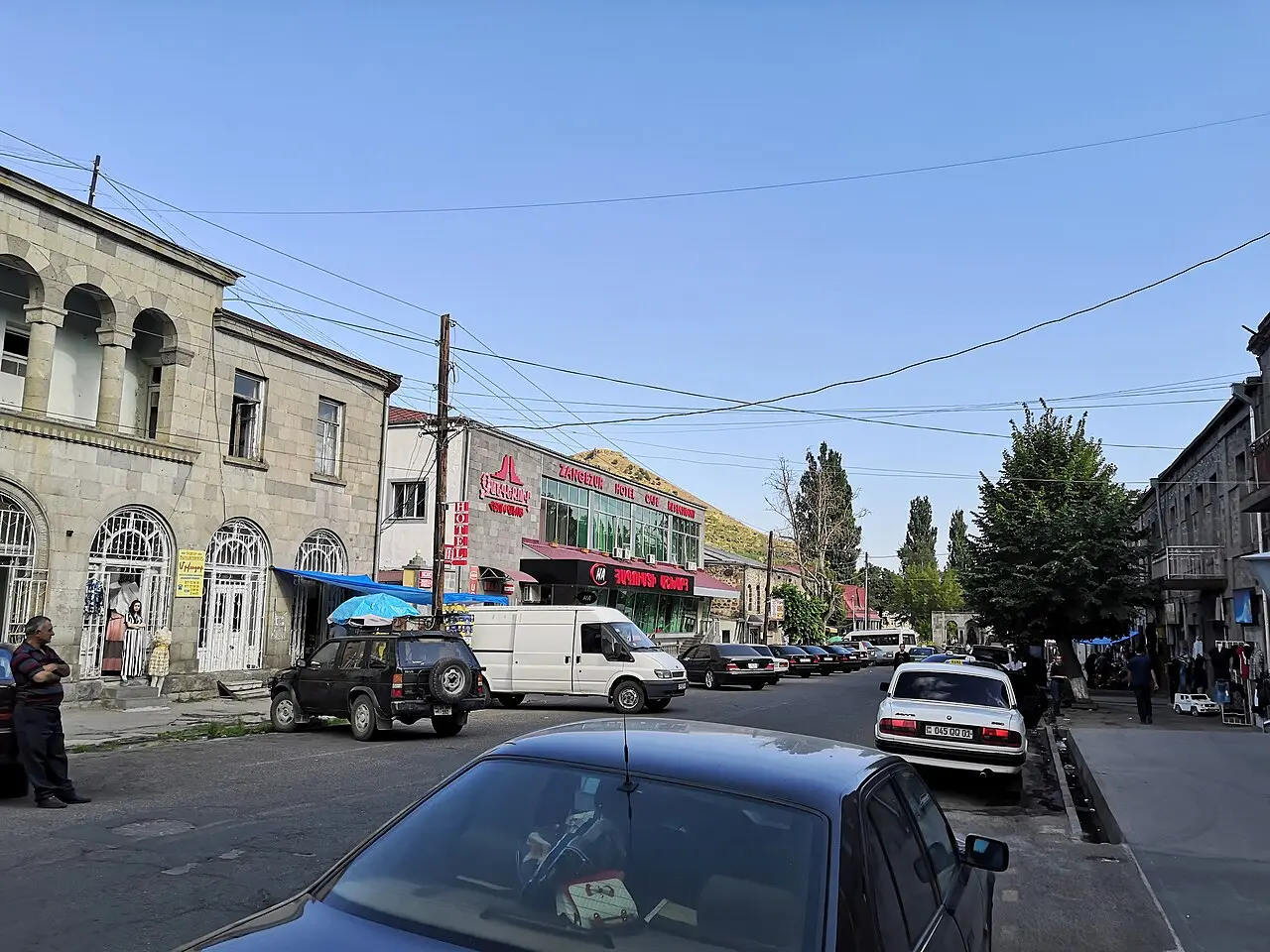 A quiet street of low black-and-grey stone houses with carved facades in the old part of Goris