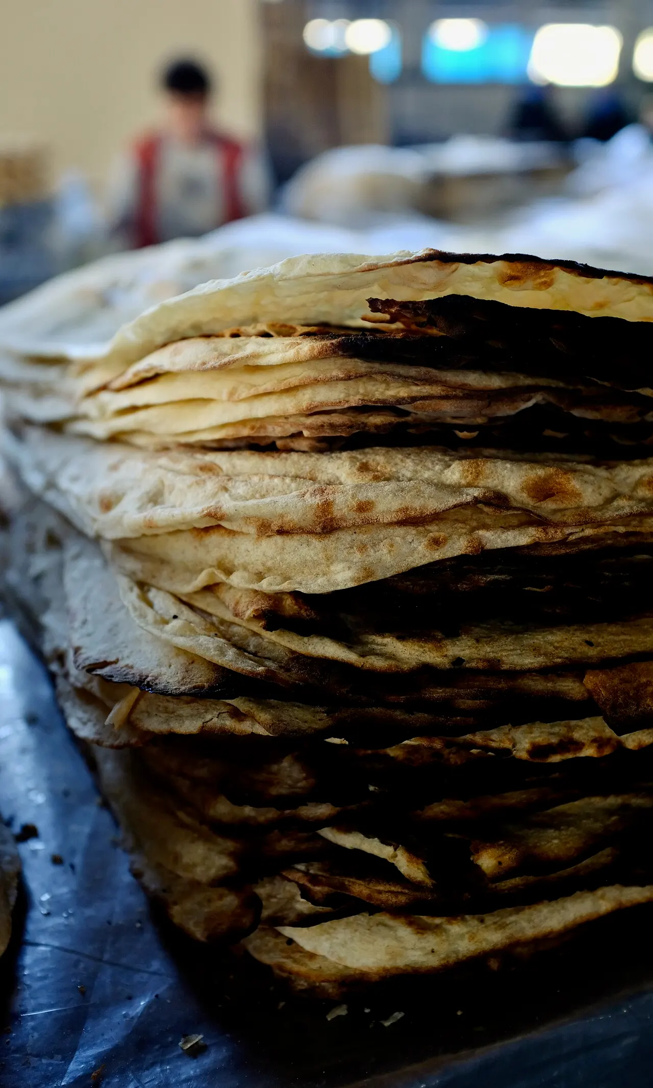 Bundles of dried lavash flatbread stacked high at a stall in GUM Market, Yerevan