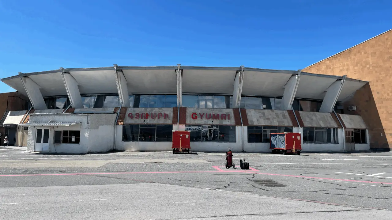 The mid-century terminal building of Gyumri Shirak Airport with the name GYUMRI in red lettering across the front